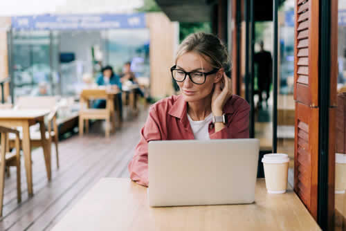 Woman working remotely in cafe
