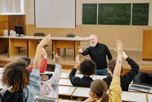 Teacher engaging with students in a lively classroom discussion